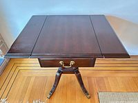 Top view showing both drop leaves extended and drawer front with brass pull
