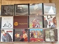 All twelve CD jewel cases laid out in three rows