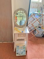 All items grouped: side table, mirror, insoles, metal stand on table, scale leaning below