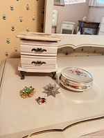 All items grouped: trinket container, jewelry box, two brooches, ring