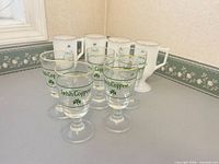 Group shot showing all six clear glasses and four milk glass mugs