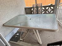Rectangular white metal patio table with tempered glass top