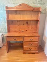 Front view showing desk with four drawers and attached hutch with two shelves