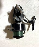Full view of Mitchell 301 fishing reel showing body, handle, bail arm, and green-lined spool