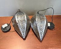 Two silver-tone perforated metal teardrop lanterns with attached solar panel discs