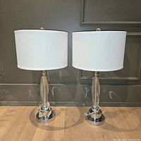 Both glass and chrome table lamps with shades displayed