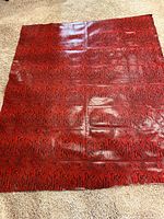 Entire red vinyl snakeskin remnant laid flat showing size and pattern