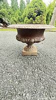 Side view showing entire cast iron urn planter with pedestal base
