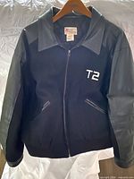 Front view showing zipper, T2 embroidery, pockets, collar, leather sleeves