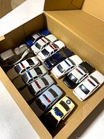 Box containing rows of diecast police cars and the silver-plated car bank
