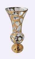 Full view of gold tapered footed vase showing silver oval pattern and pedestal base