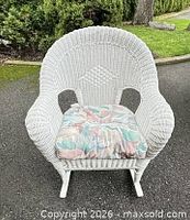 Front view of white wicker rocking chair with cushion