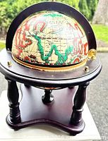 Globe ice bucket on dark wood stand showing overall design