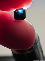 Octagon blue spinel held between fingers showing face-up color
