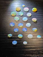 All 22 Ethiopian opal cabochons arranged on black surface