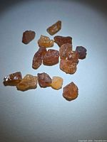 Group of orange spessartite garnet crystals on flat surface