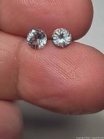 Both aquamarines held between fingers showing size and cut