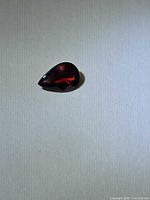 Top view of pear-cut garnet showing faceting and color