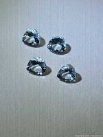 Four pear-shaped aquamarines on neutral background