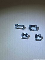 Four aquamarine gemstones showing various cuts