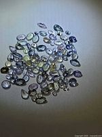 Group of loose faceted multicolour tanzanite stones under light