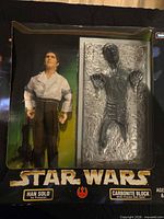 Front of sealed box showing Han Solo figure, carbonite block, blaster