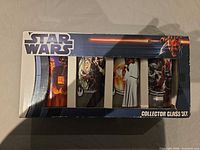 Front of boxed Star Wars collector glass set showing four tumblers through window