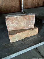 Two reclaimed bricks stacked showing surface texture and coloration