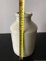 Off-white stoneware vase with tape for scale