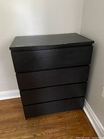 Front view of black four-drawer dresser