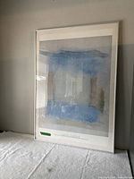 Full view of framed abstract print standing against wall