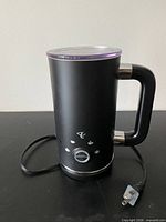 Black electric milk frother full view with cord and lid