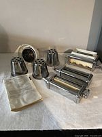Group shot showing pasta roller, two cutters, rotor slicer housing, two drums, plastic hopper, booklet