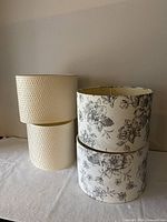 Front view showing two cream textured shades stacked and two floral shades stacked