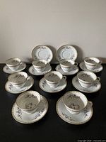 Nine cup and saucer sets displayed on table