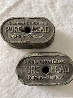 Top view of both lead ingots showing brand stamping and central holes