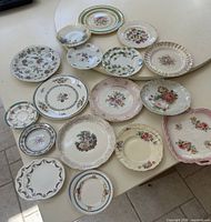 Top view of 17 assorted plates and pink handled tray on table