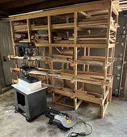 Wide view of drill press, scroll saw and large lumber rack loaded with wood