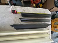 Three black shelves and two white shelves measured for length