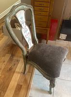 Front angle view of chair showing frame finish, seat upholstery, and painted back panel