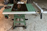 Table saw front view showing fence, miter gauge, blade, power switch and stand