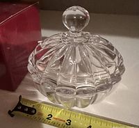 covered candy dish beside tape measure