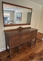 Sideboard with mirror mounted above, showing overall form and proportion
