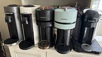 Front view showing five Nespresso machines lined up in various colors