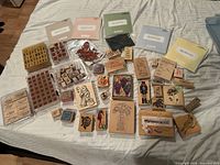 Full spread of wood-mounted stamps, clear sets, and storage folders on bed