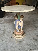 Full view of table showing travertine top and cherub base