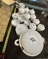 Overall lot showing tureen, covered bowls, saucers, escargot plates on countertop