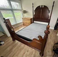 Full view of assembled bed frame showing headboard, footboard, side rails and box spring
