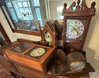 Group shot of four wooden clocks on sideboard