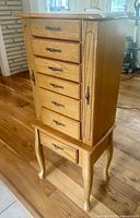 Front view of oak jewelry armoire on cabriole legs
